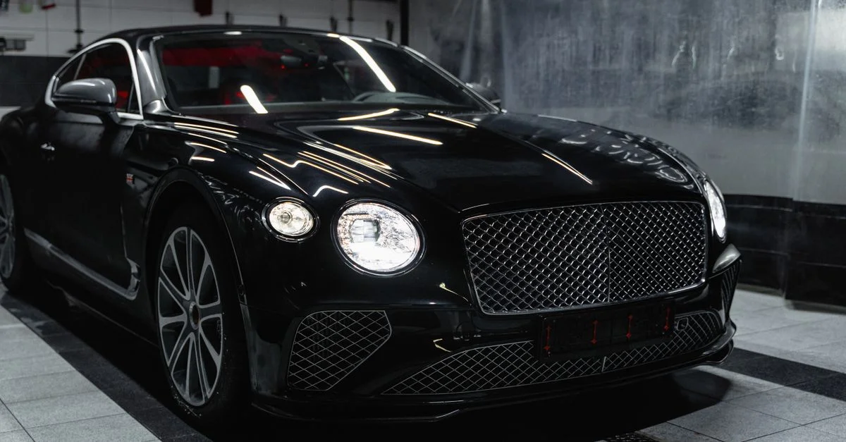 Voiture de luxe noire élégante dans un car wash moderne intérieur, mettant en valeur l'élégance et la sophistication.