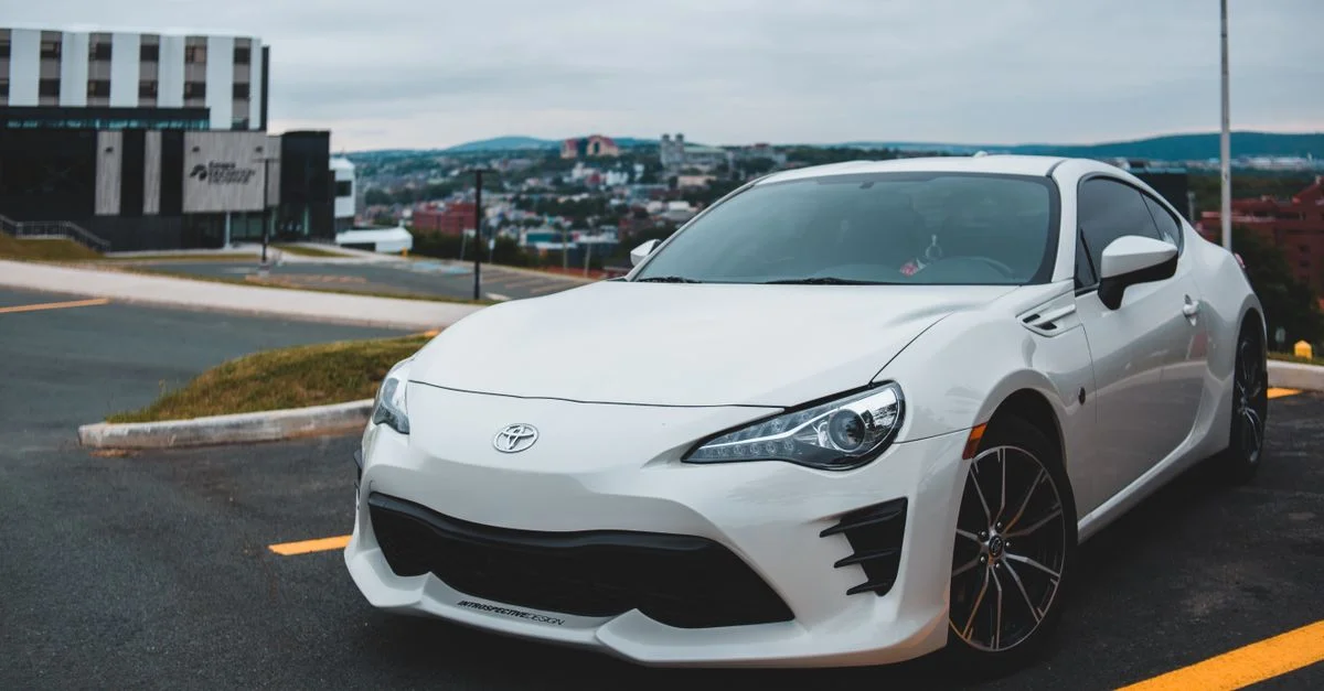 Une voiture de sport blanche élégante garée dans un environnement urbain, mettant en valeur un design moderne.