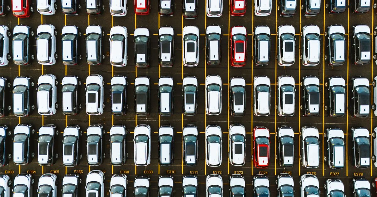 Une vue aérienne capturant une disposition symétrique de voitures garées dans un parking.
