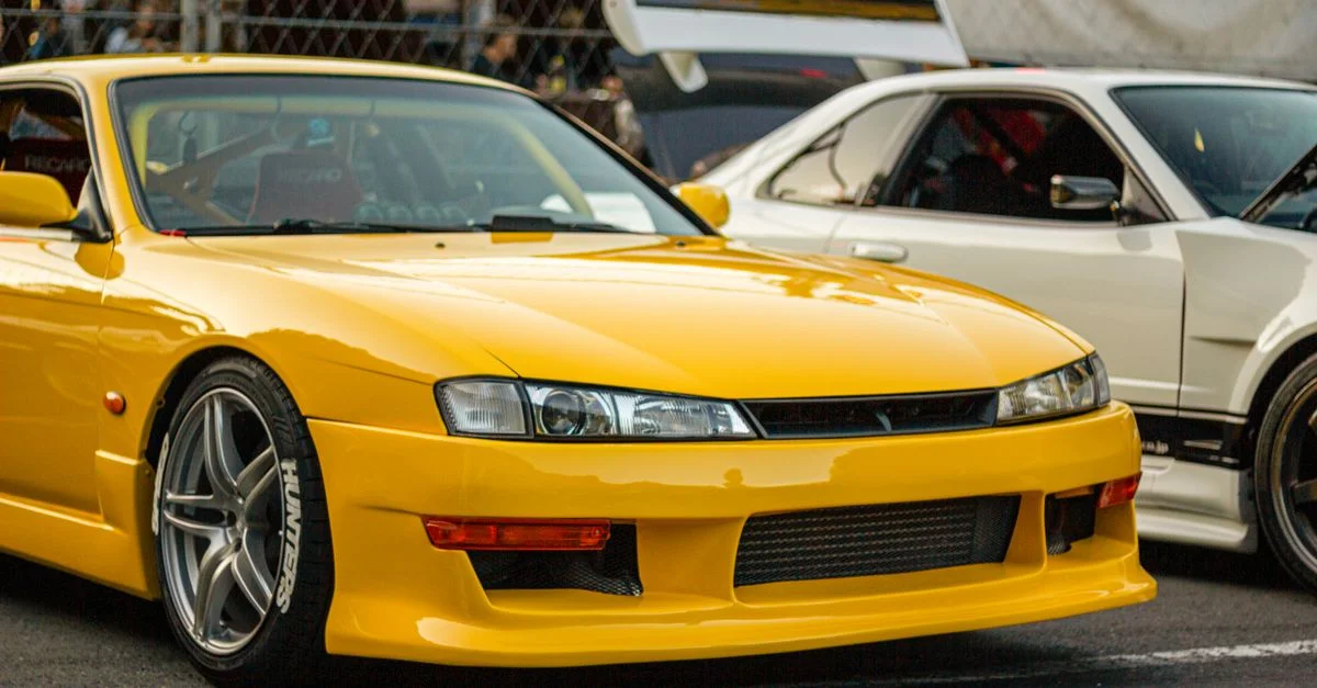 Gros plan sur une voiture de sport jaune modifiée lors d'un salon automobile en plein air.